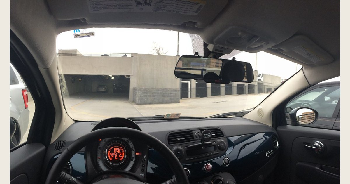 A rearview-mirror dash cam installed in a Fiat 500, viewed through the windshield area.